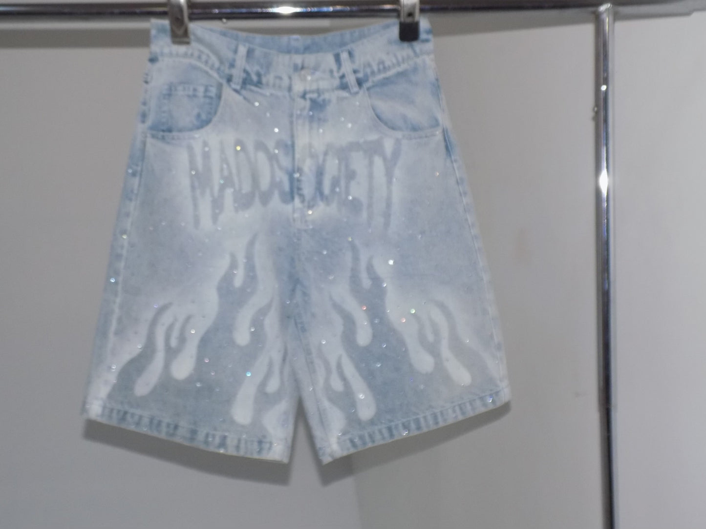 Light blue denim shorts with white patterns on a white background